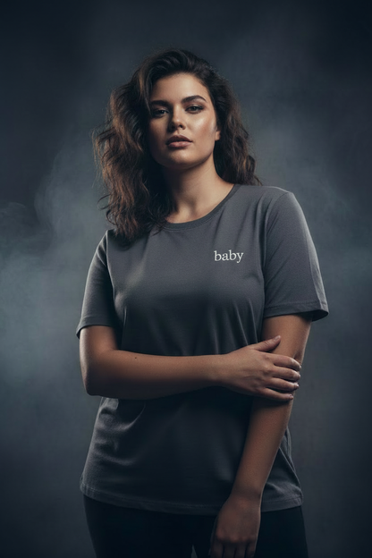 Plus size model wearing tee with small cursive baby lettering on upper left chest